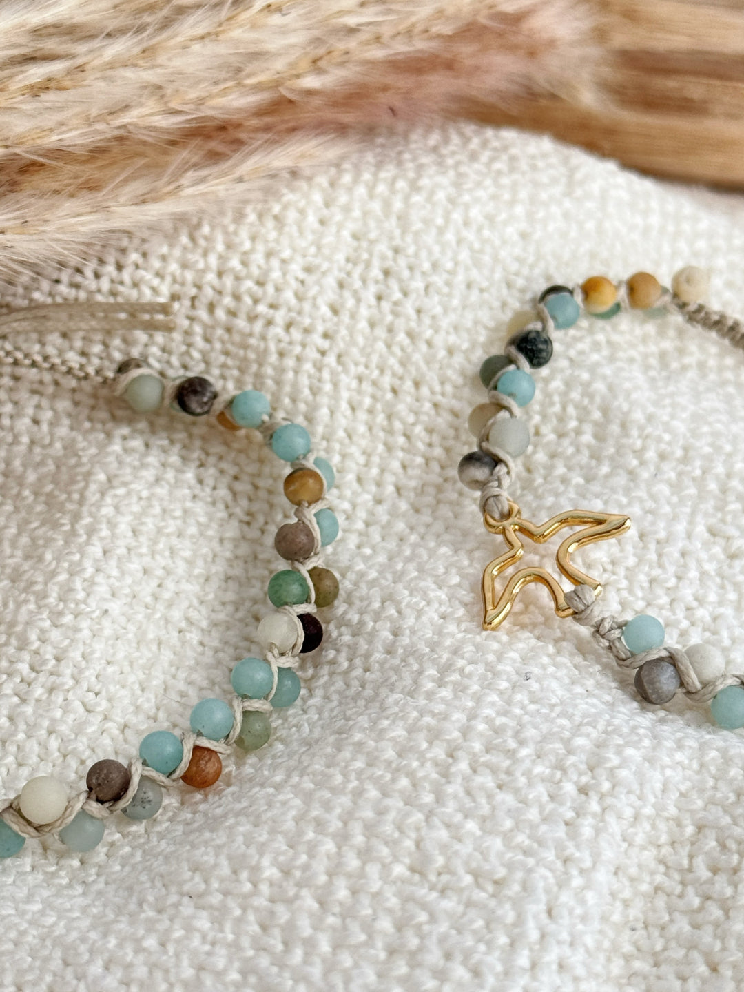 צמיד Mosaic הוא צמיד מקרמה עדין, עשוי שילוב של חוט שעווה בגוון אוף-וויט עם חוט פוליאסטר דק, ומשובץ חרוזי אמזונייט בגוון בהיר ומט.
המראה הנקי והמרקם הרך של האבנים יוצרים תחושה של הרכב שקט ומאוזן, כמו פסיפס עדין של פרטים קטנים שמתחברים יחד. העיצוב שומר על קו מינימליסטי אך לא אחיד, עם משחק קל של צבעים וטקסטורות שנותן מקום לפרשנות אישית.
הצמיד נעשה בעבודת יד מדויקת, ומתאים למי שמחפשת תכשיט עם נוכחות שקטה ונאמנות לפרטים הקטנים.