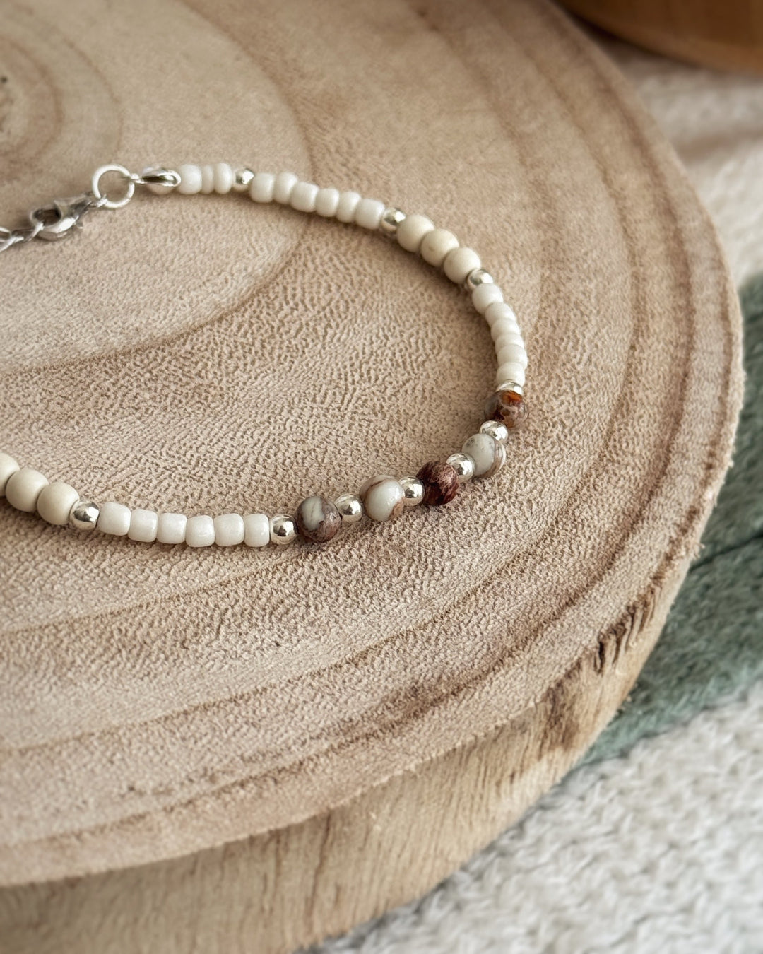 צמיד Pebble הוא צמיד חרוזים עדין בעבודת יד, בגווני לבן, קרם וחום טבעי שמזכירים חלוקי נחל קטנים. השילוב בין החרוזים הרכים לאלמנטים הכסופים יוצר מראה רגוע ונקי שמתאים לכל רגע ביום