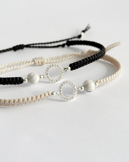 צמיד מקרמה עדין מדגם Halo, עם אלמנט עגול מצופה זרקונים ואבן Howlite לבנה, מצולם על רקע נקי