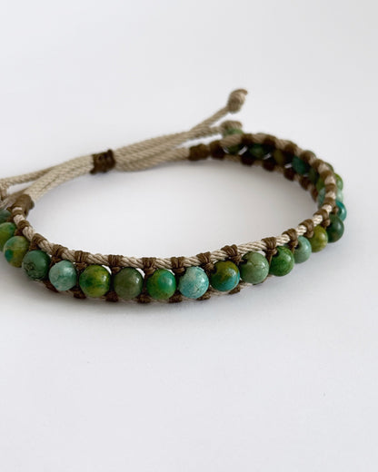 צמיד Creek בעבודת יד עם חרוזי טורקיז אפריקאי וחוטים טבעיים בגווני ירוק ומים על רקע בהיר