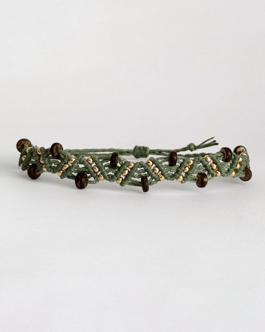 צמיד מקרמה Grove בירוק זית עם חרוזי עץ כהים וחרוזים מוזהבים, מצולם על רקע נקי.