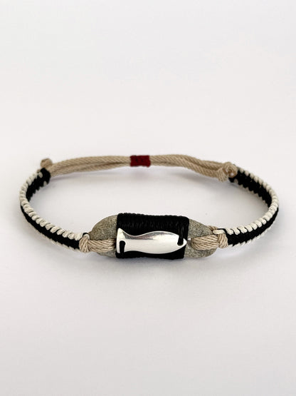 Macramé bracelet combining natural stone, black and beige cords, and silver fish charm