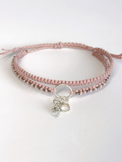 צמיד מקרמה כפול בגוון ורוד בייבי עם שרשרת זירקונים שזורה ותליוני כסף של חתול ופעמון - צמיד Stardust של Lala Fshasha.
