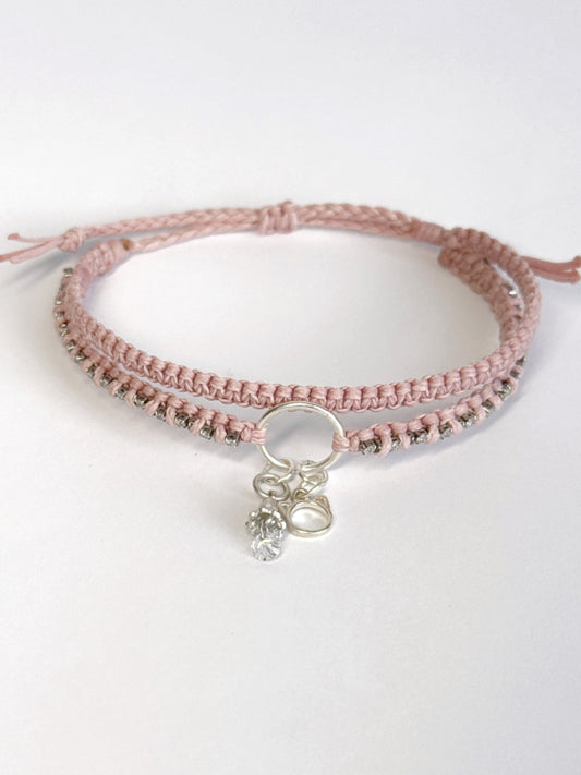 צמיד מקרמה כפול בגוון ורוד בייבי עם שרשרת זירקונים שזורה ותליוני כסף של חתול ופעמון - צמיד Stardust של Lala Fshasha.