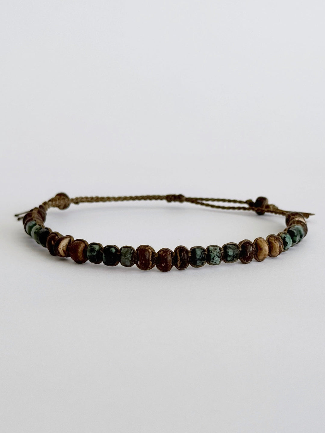 צמיד מקרמה בעבודת יד משולב חרוזי עץ טבעי ואבני חן טורקיז אפריקאי בגווני ירוק וחום - צמיד Oxide של Lala Fshasha.